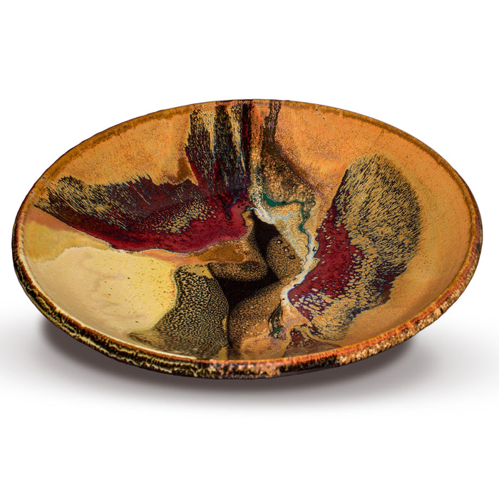 Beautiful handmade pottery bowl in earth tone colors accented with red.  Handmade pottery by Prairie Fire Pottery.  Made in the U.S.A.  Stoneware clay high-fired to 2400°.  3/4 view.