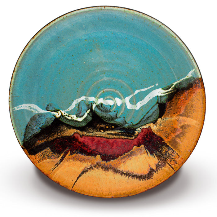 A large turquoise-brown bowl with ribbons of white and a swath of red over toasted brown.  Overhead view.