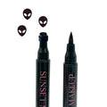 Two black Sunset Makeup alien stamp eyeliner applicators displayed on a white background with a black alien stamp impression.