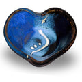 Cobalt blue and black bowl in the shape of a heart.  It's handmade pottery from Prairie Fire Pottery.  Hand made in stoneware clay.  Overhead view.