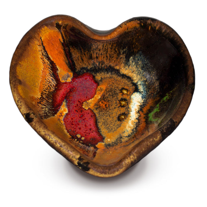 Heart-shaped bowl in toasted orange and black with red accents. Handmade pottery by Prairie Fire Pottery.  Overhead view.