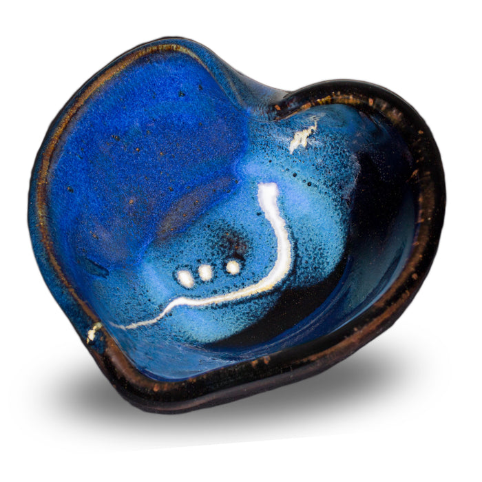 Cobalt blue and black bowl in the shape of a heart.  It's handmade pottery from Prairie Fire Pottery.  Hand made in stoneware clay.  3/4 view.
