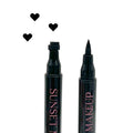 Two black Sunset Makeup heart stamp eyeliner applicators displayed on a white background with a black heart stamp impression.