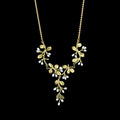 A green necklace with a leafy vine pendant featuring small white pearl-like drops, shown against a solid black background.