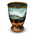10 ounce turquoise cup accented with toasted orange and ribbons of white.  Handmade pottery by Prairie Fire Pottery.  Hand made in stoneware clay and high-fidred to 2400°.