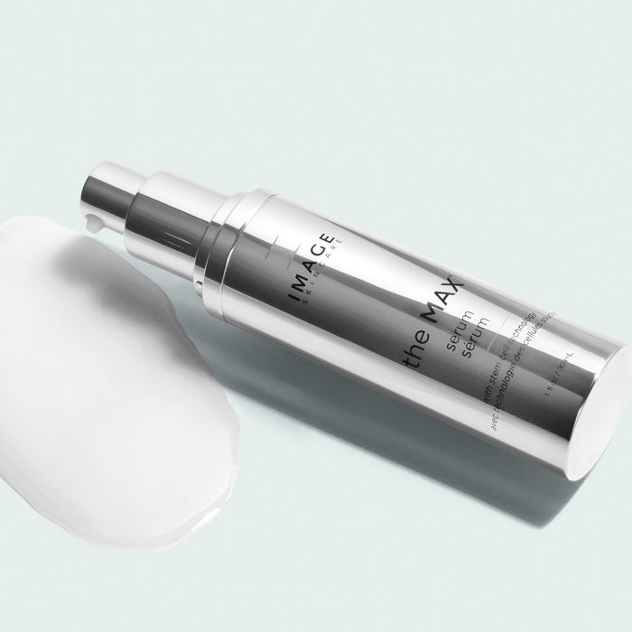 max serum bottle opened and dispensing product on light background