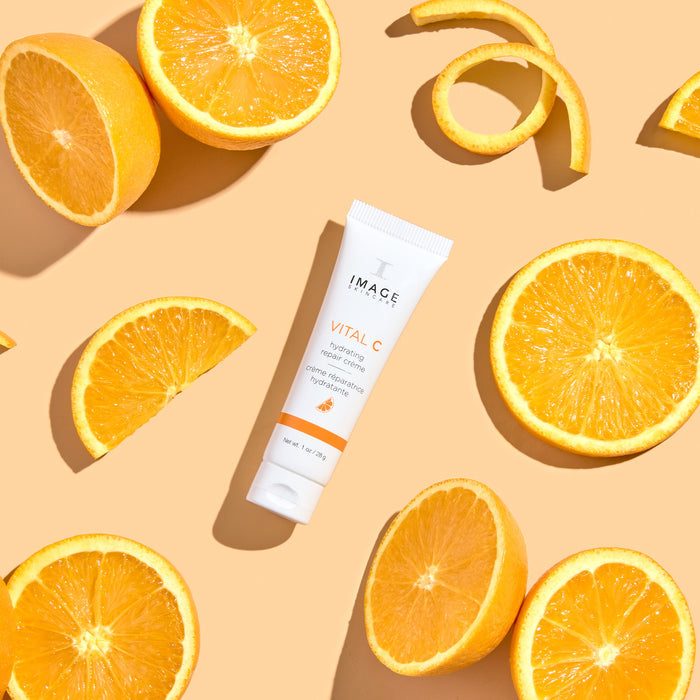 travel size repair creme on orange background with orange slices